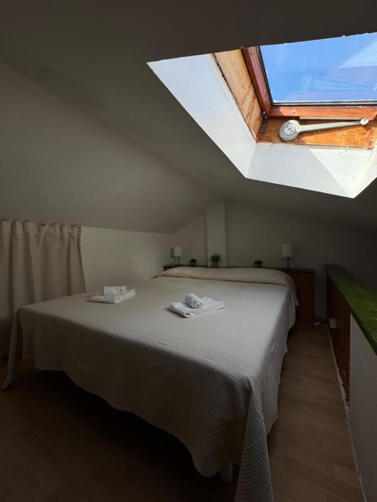 une chambre avec un grand lit avec une lucarne dans l'établissement La casa al Rais, à Finale