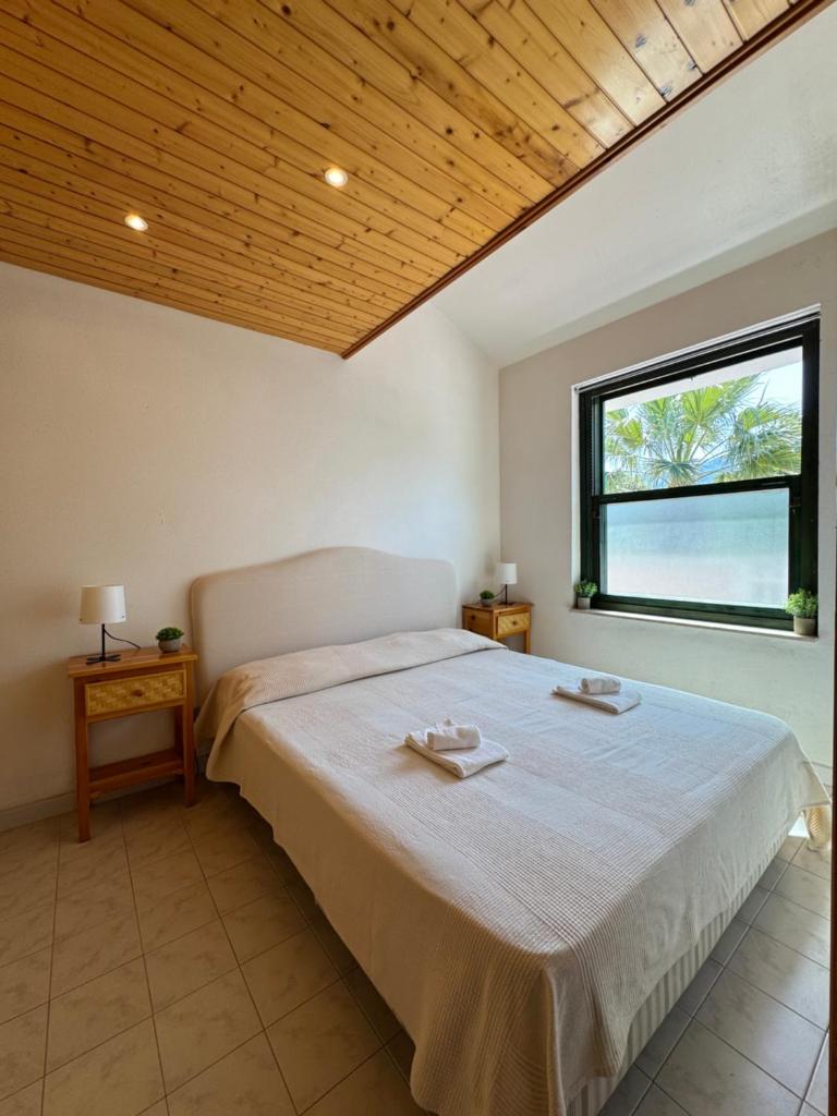 une chambre avec un grand lit et une fenêtre dans l'établissement La casa al Rais, à Finale