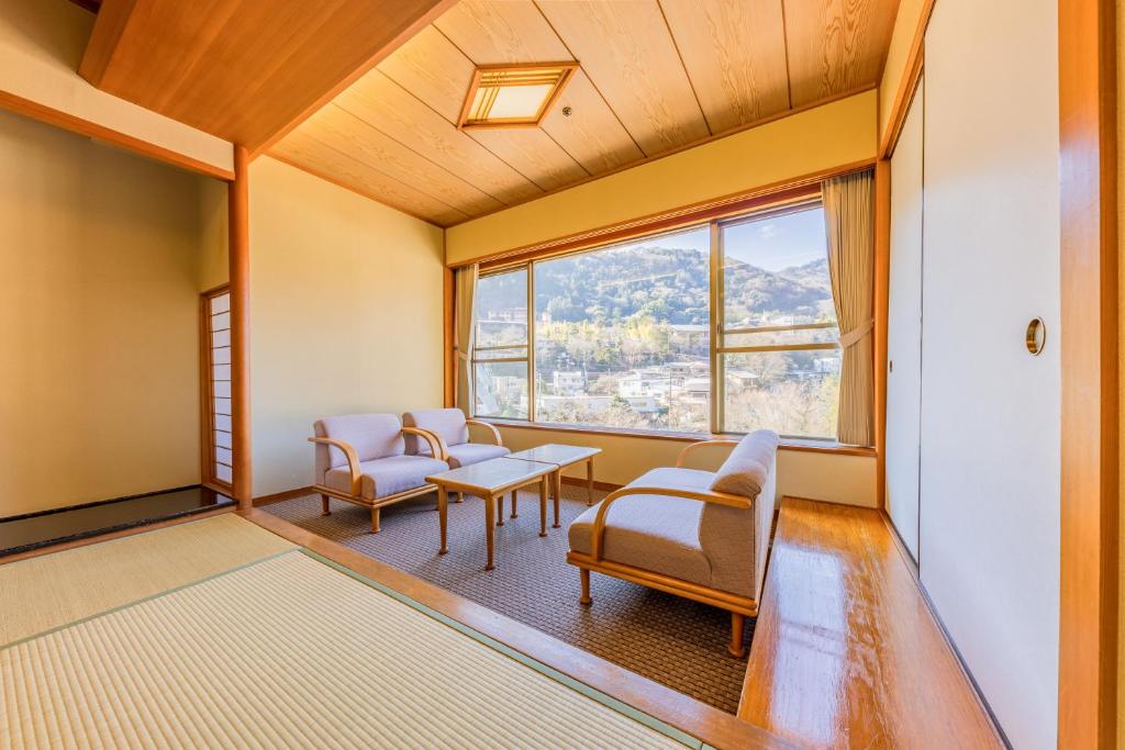 une pièce avec des chaises, une table et une fenêtre dans l'établissement Hakone Yumoto Onsen Hotel Kajikaso, à Hakone
