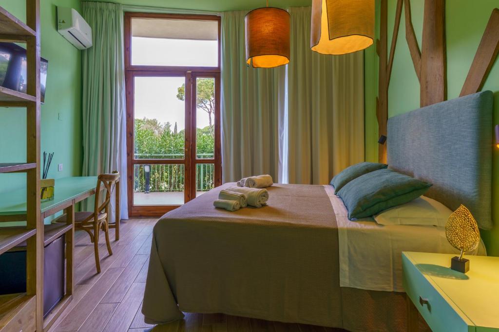 une chambre avec un lit, une table et une fenêtre dans l'établissement CSA Hotel Beach & Park, à Marina di Bibbona