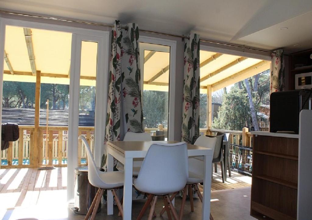 une salle à manger avec une table et des chaises dans l'établissement Mobilhome Gamme résidentielle, au Muy