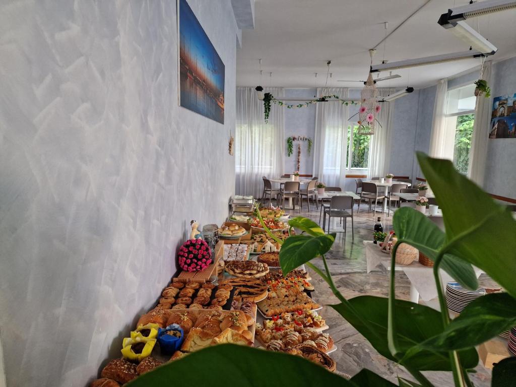 une longue table remplie de différents types de pâtisseries dans l'établissement Beach Hotel Clerice, à Rimini