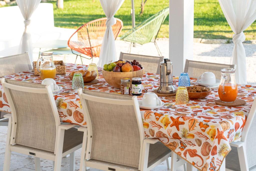 - une table avec un petit-déjeuner composé de fruits et de jus de fruits dans l'établissement Villa L'Ulivo by Bianco Puglia Vacanze, à San Vito dei Normanni 29 autres photos