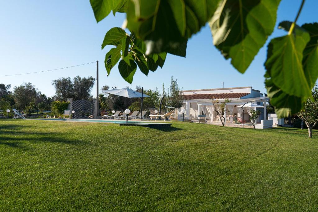 un parc avec de l'herbe verte et un bâtiment dans l'établissement Villa L'Ulivo by Bianco Puglia Vacanze, à San Vito dei Normanni
