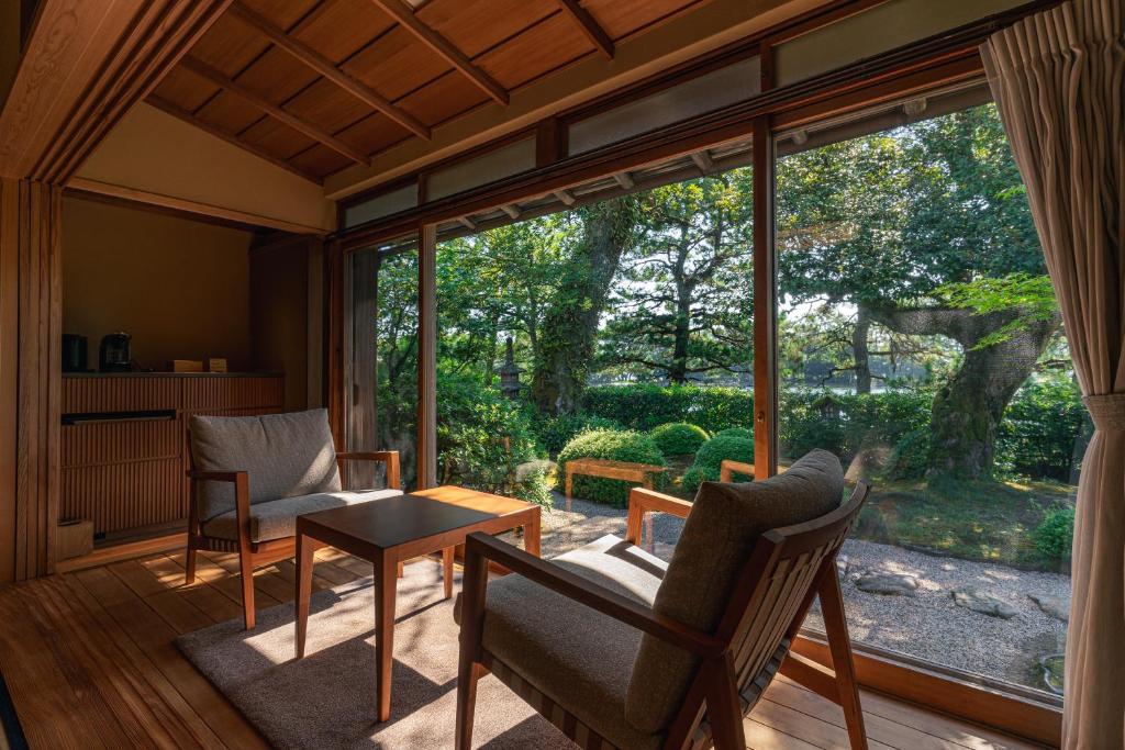 - un salon avec une grande fenêtre, une table et des chaises dans l'établissement Monjusou Shourotei, à Miyazu