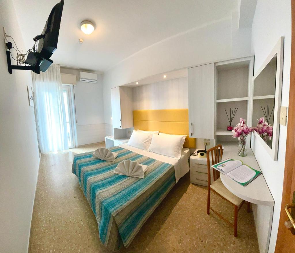 une chambre d'hôtel avec un lit, une table et un bureau dans l'établissement Hotel Crystal - SPIAGGIA INCLUSA con Formula All Inclusive, à Rimini