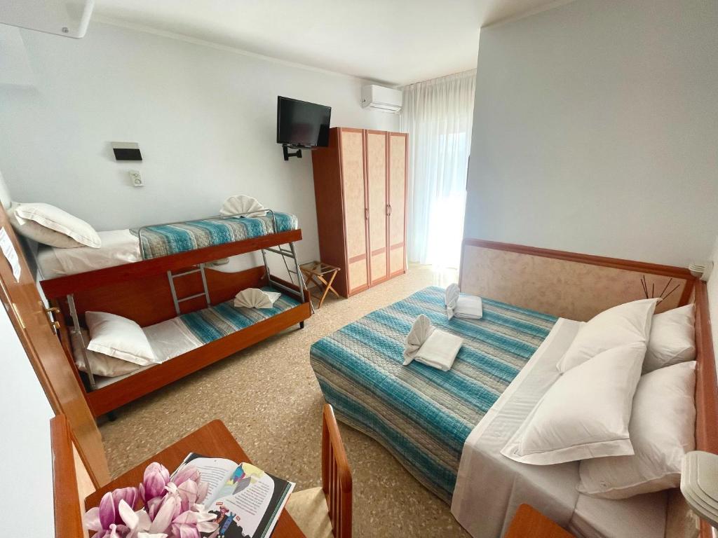 - une chambre avec 2 lits superposés et une table avec une table de sidx dans l'établissement Hotel Crystal - SPIAGGIA INCLUSA con Formula All Inclusive, à Rimini 51 autres photos