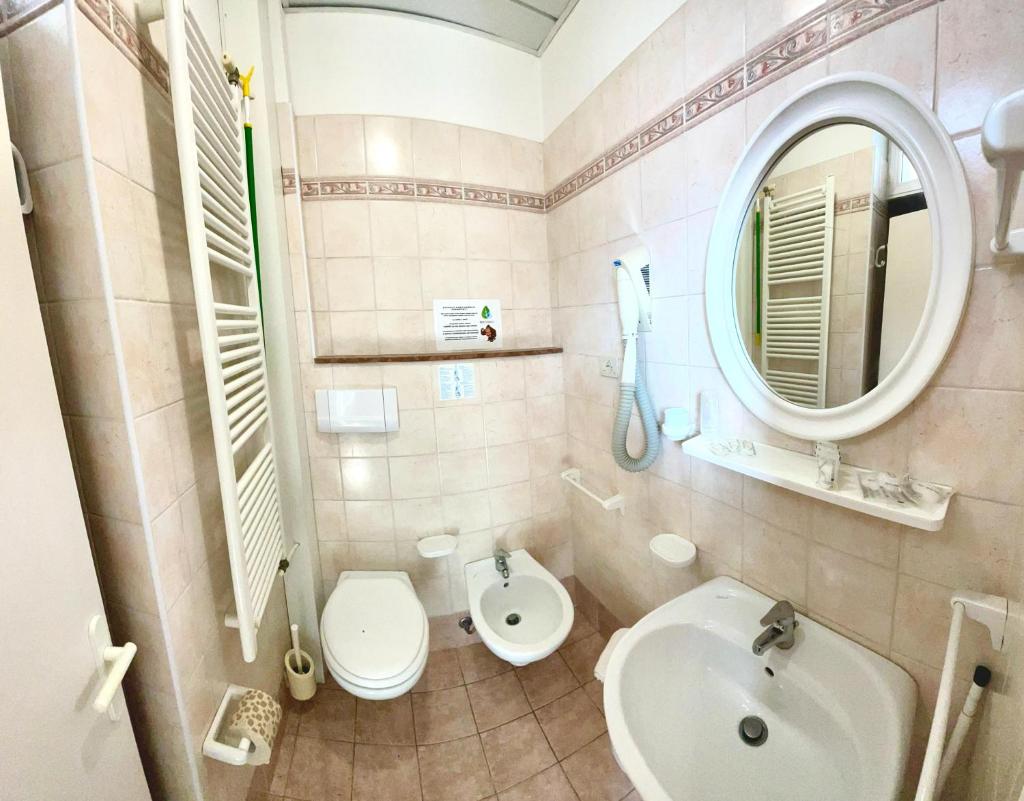 une salle de bain avec un lavabo, des toilettes et un miroir dans l'établissement Hotel Crystal - SPIAGGIA INCLUSA con Formula All Inclusive, à Rimini