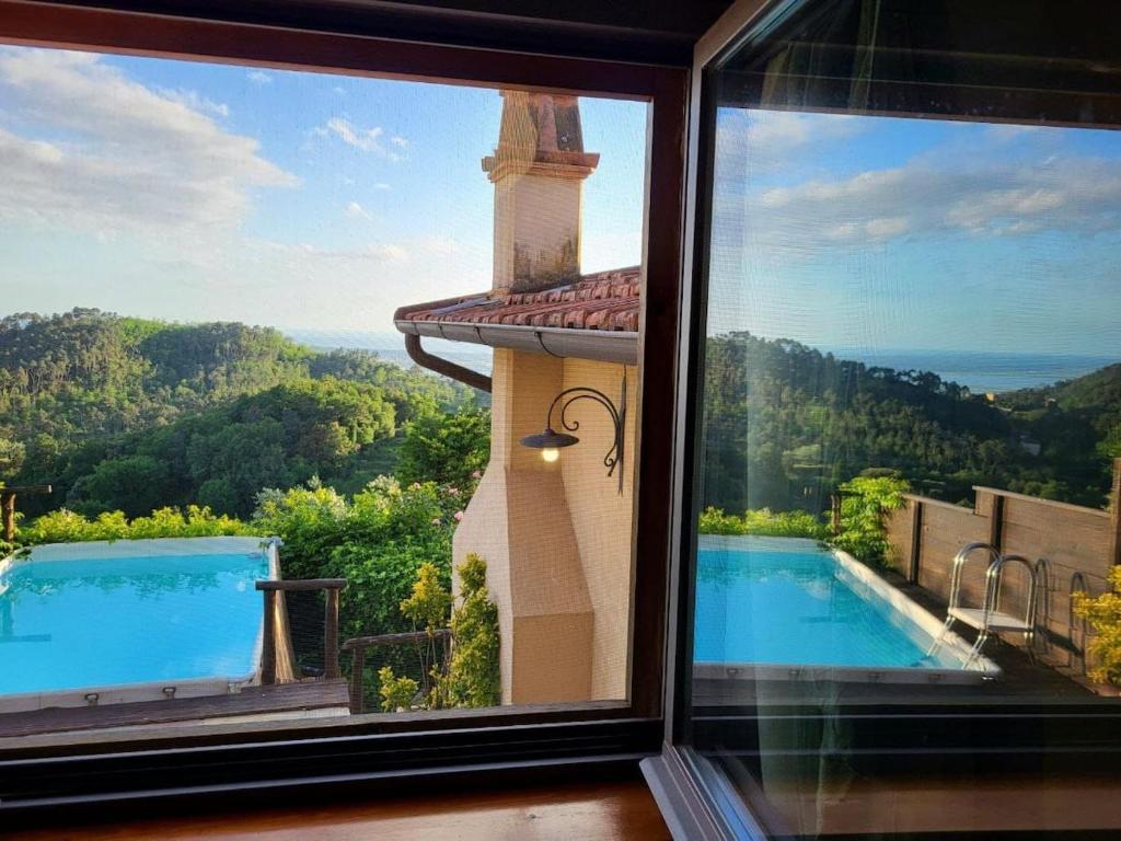 Elle offre une vue sur la piscine depuis sa fenêtre. dans l'établissement Alcova Sea view pool villa, à Montemagno