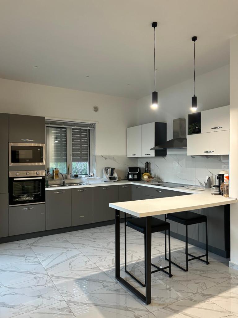 une cuisine avec une table au milieu dans l'établissement Villa Grazia, à SantʼAgata di Militello