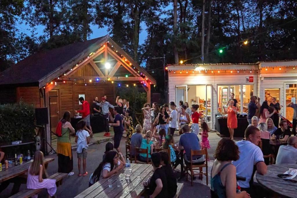 Une foule de gens se tenant autour d'une fête dans l'établissement Les mobil homes d’oliver rob, à Saint-Chéron 37 autres photos