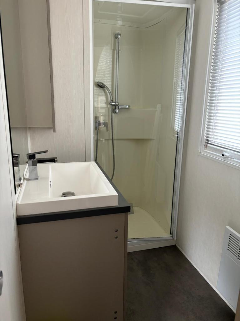 une salle de bain avec un lavabo blanc et une douche dans l'établissement Mobil home 6 personnes, à Argelès-sur-Mer