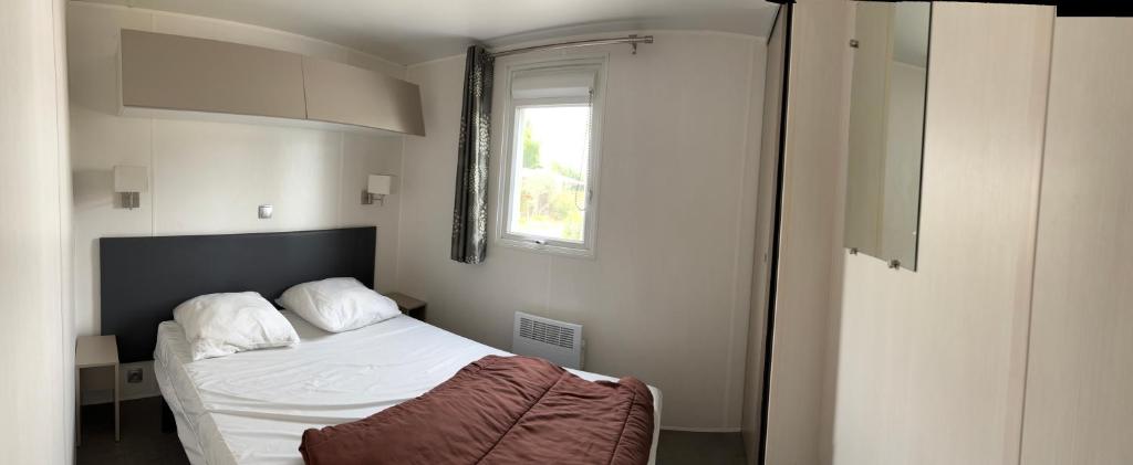 une petite chambre avec un lit et une fenêtre dans l'établissement Mobil home 6 personnes, à Argelès-sur-Mer