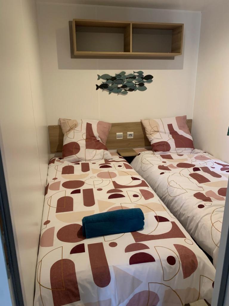 une chambre avec deux lits jumeaux dans une pièce dans l'établissement Au Petit Bonheur, à Vias