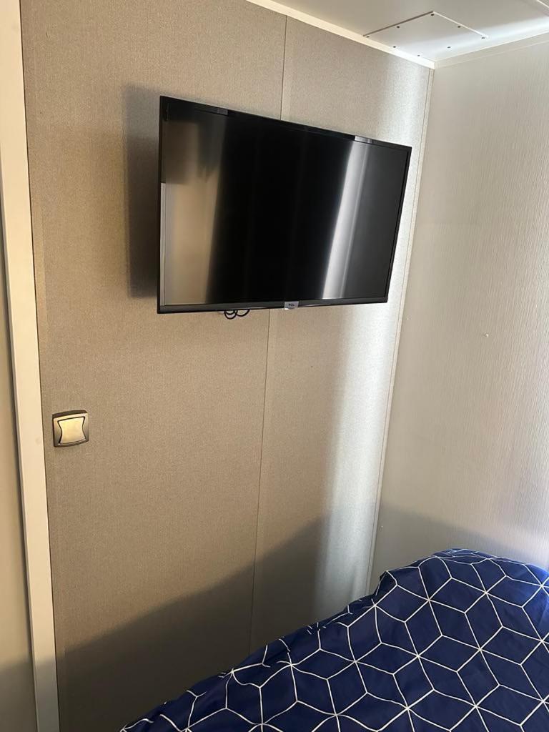 - une télévision à écran plat sur le mur d'une chambre dans l'établissement mobilhomme 3 Chambres avec piscine, à Camiers