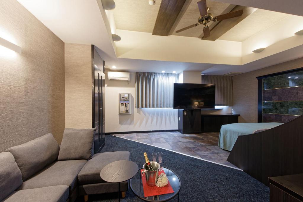 un salon avec un canapé et une télévision à écran plat dans l'établissement ホテル Ano, à Kanuma