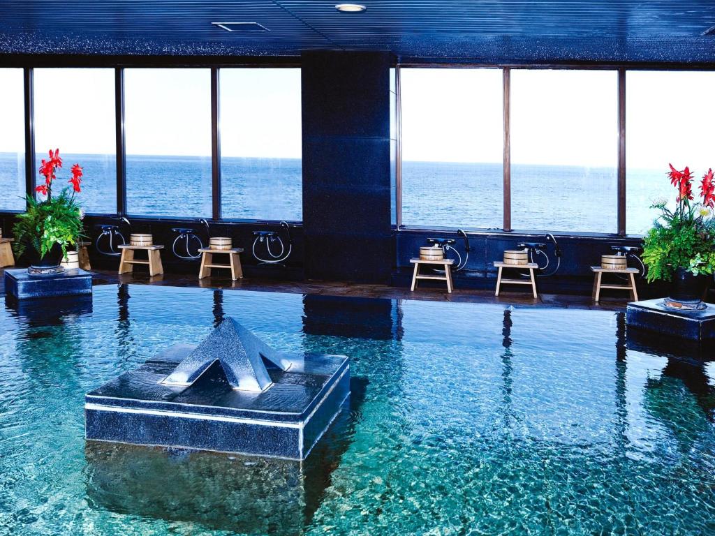 une piscine avec un monument au milieu de l'eau dans l'établissement Hotel Resorpia Atami, à Atami