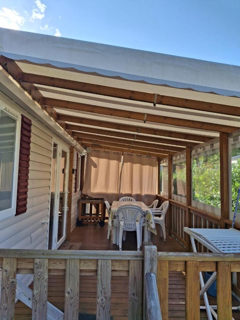 une terrasse en bois avec une table et un patio dans l'établissement repos merite, à Gastes 5 autres photos