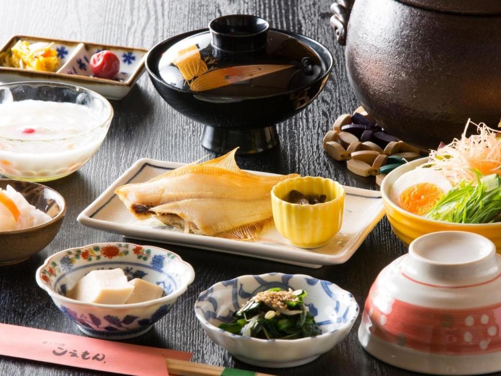 une table recouverte de bols et de assiettes de nourriture dans l'établissement 癒しの宿 こえもん, à Kami