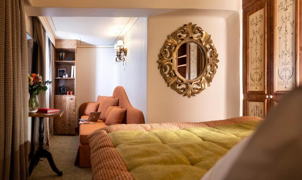 une chambre avec un lit et un miroir au mur dans l'établissement Hôtel de la Loze, à Courchevel