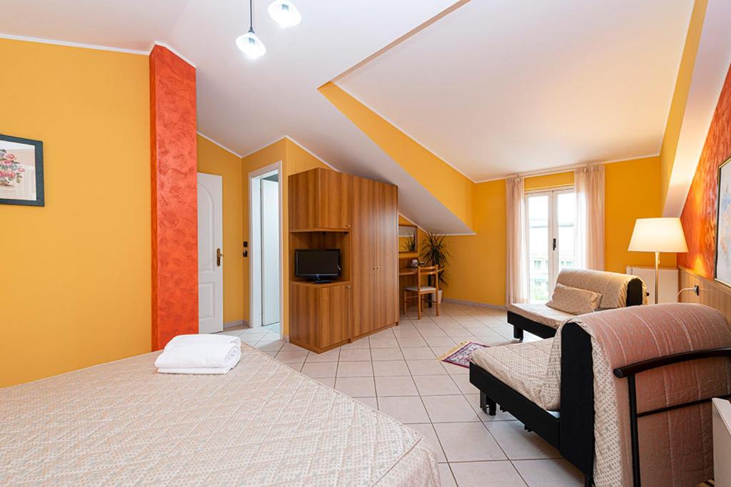 une chambre avec des murs jaunes et un lit et un canapé dans l'établissement La Lanterna, à Silvi Marina