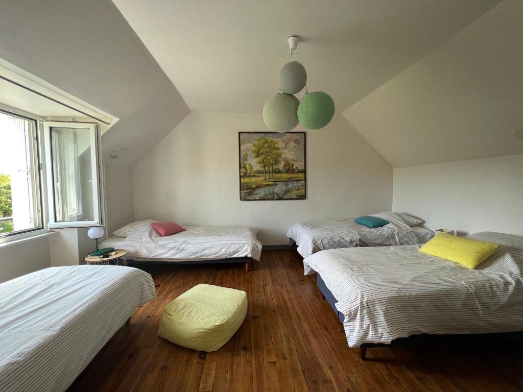 une chambre avec trois lits et une fenêtre dans l'établissement Maisons Les Gites de l'Odet, à Clohars-Fouesnant