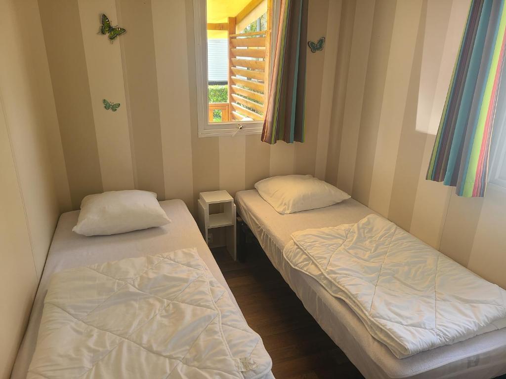 deux lits dans une petite pièce avec une fenêtre dans l'établissement chez audrey C21, à Boofzheim