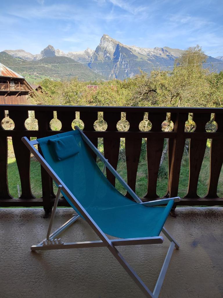 une chaise bleue assise sur un balcon avec vue dans l'établissement Le Gypaète, à Morillon