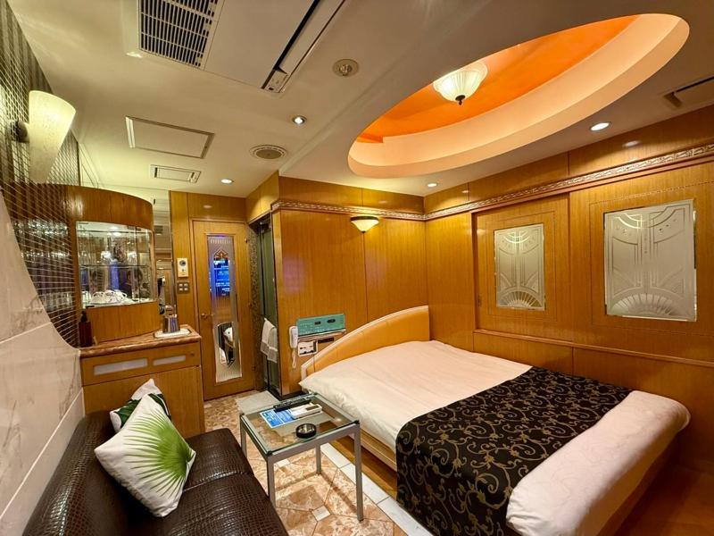 une petite pièce avec un lit et un canapé dans l'établissement Hotel Apio, à Tokyo