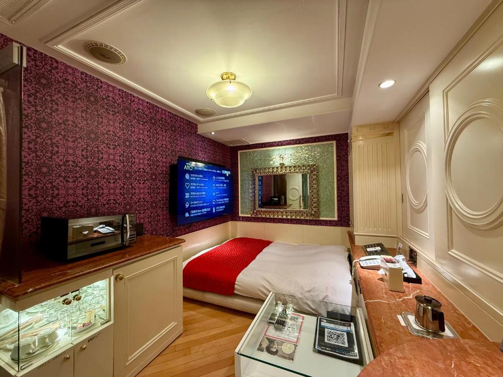 une chambre avec un lit et une télévision dans l'établissement Hotel Apio, à Tokyo
