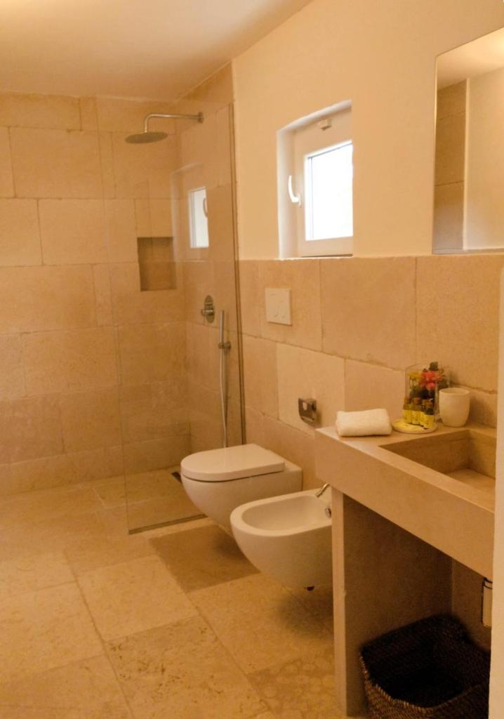 une salle de bain avec toilettes, douche et lavabo dans l'établissement Villa Pupetta Ostuni 4 bedrooms 4 bathrooms - swimming pool, à Ostuni