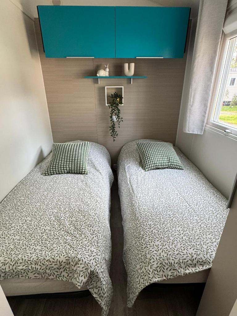 deux lits côte à côte dans une chambre dans l'établissement Mobil Home MarieVa "Les dunes de Contis", à Saint-Julien-en-Born 24 autres photos