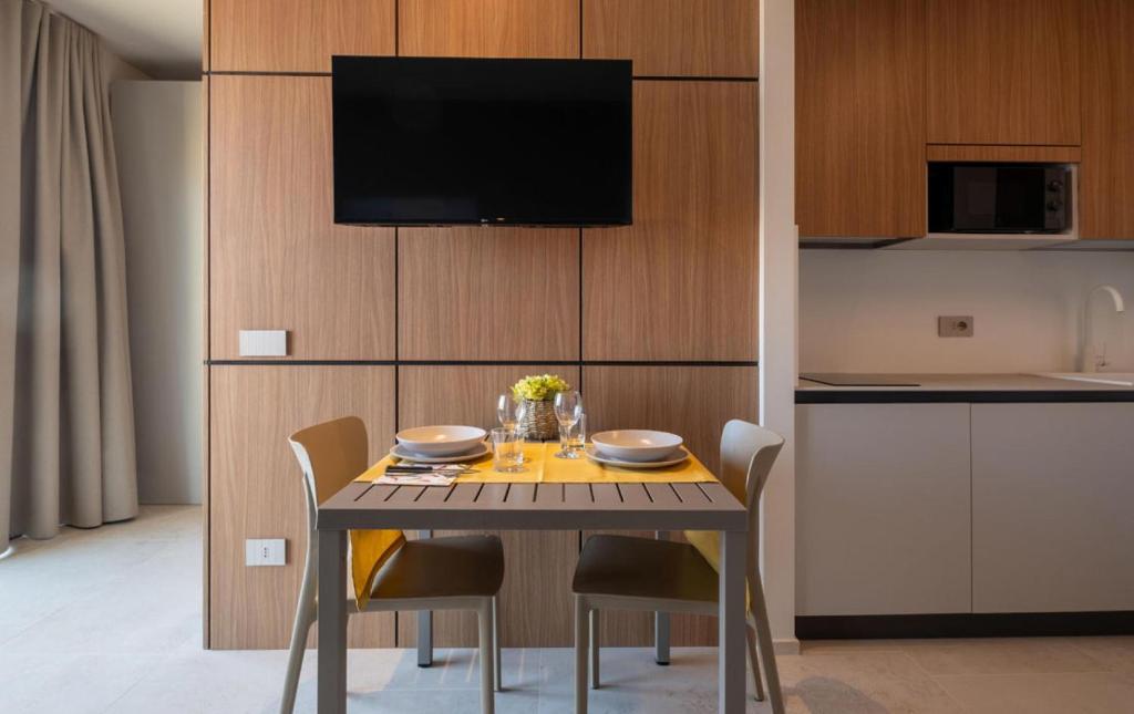 une table à manger avec des chaises et une télévision dans l'établissement G Palace Residence, à Civitanova Marche 5 autres photos