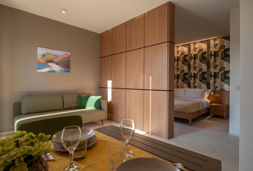 - un salon avec un canapé et une table avec des verres à vin dans l'établissement G Palace Residence, à Civitanova Marche