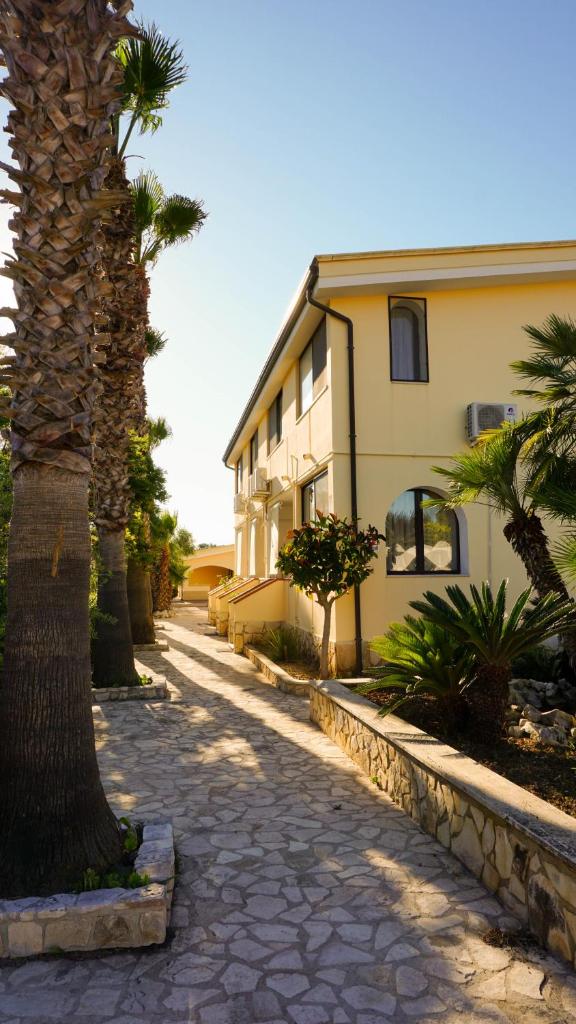une rue avec un bâtiment et un palmier dans l'établissement Residence Club Solemare, à Vieste