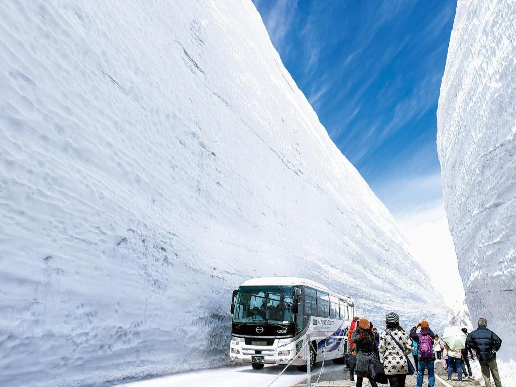 un groupe de personnes debout devant un bus dans l'établissement Tsurugi Koizuki, à Kamiichi