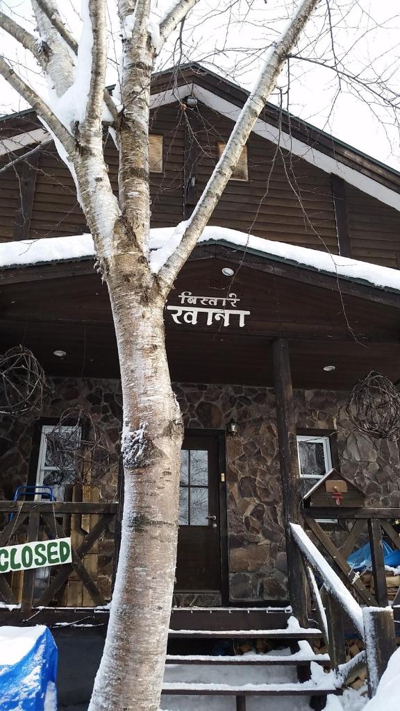 un bâtiment avec un arbre devant lui dans l'établissement Bistare Kana, à Niseko