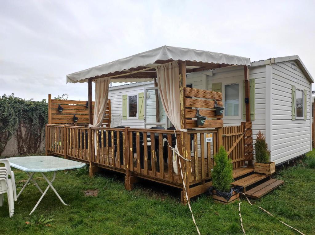 une petite maison avec une terrasse et une table dans l'établissement Mobil home 6 personnes, à Boofzheim