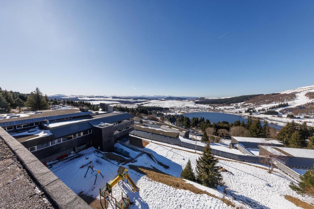 une vue aérienne sur un bâtiment dans la neige dans l'établissement Belambra Clubs Superbesse - Le Chambourguet, à Super-Besse