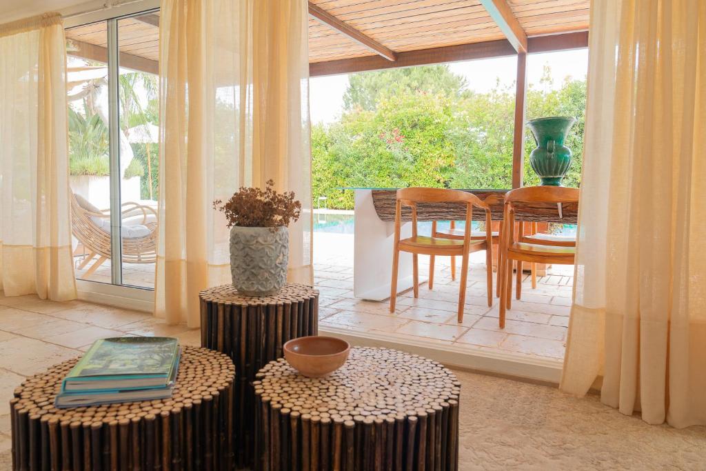 - un salon avec deux tables et une table avec des chaises dans l'établissement Villa Flora, à Depressa