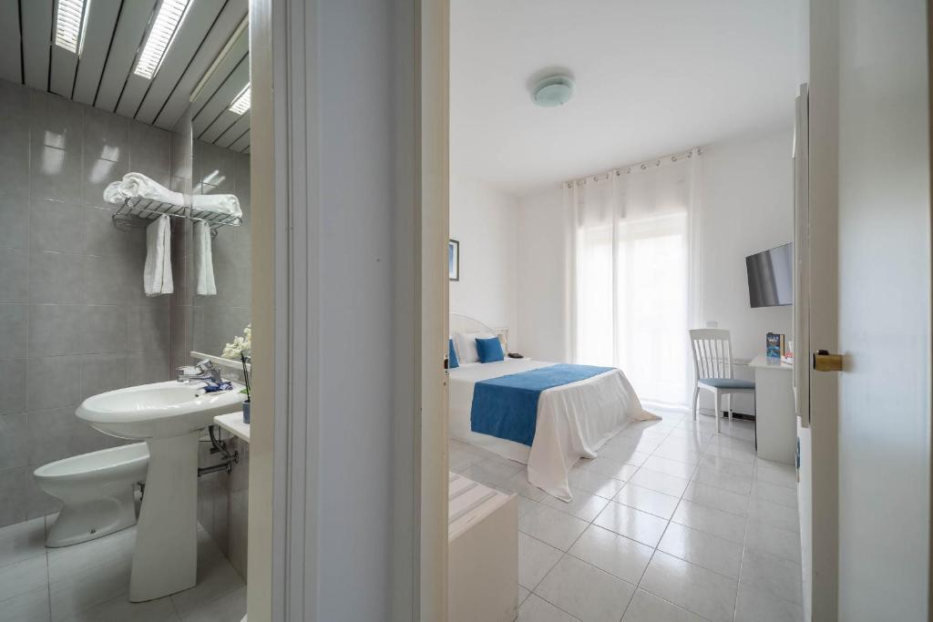 une chambre avec un lit et une salle de bain avec un lavabo dans l'établissement Hotel Panorama, à Maiori