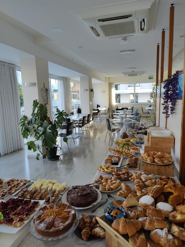 - un bouquet de différents types de pains et de pâtisseries sur les tables dans l'établissement Hotel Kim, à Rimini