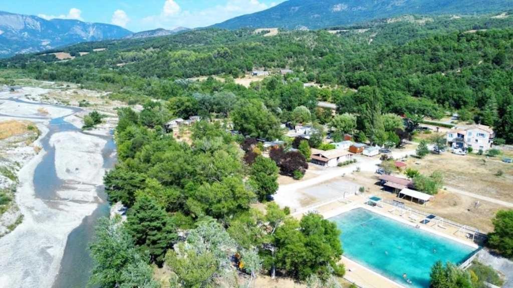 - une vue aérienne sur un complexe avec une piscine et une rivière dans l'établissement Camping 3 étoiles - Piscine - ccbaehg, à Mézel