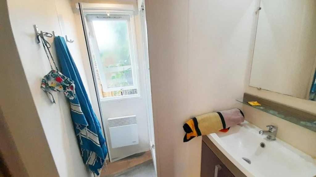 une salle de bain avec un lavabo et un rideau de douche dans l'établissement Camping 3 étoiles - Piscine - ccbaehg, à Mézel