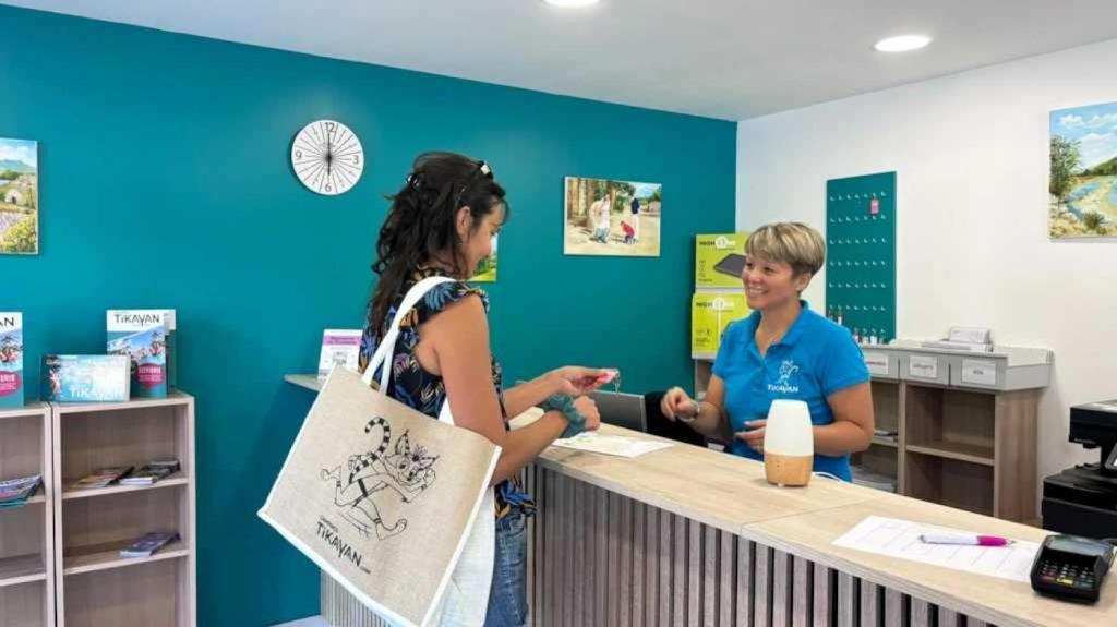 un homme et une femme debout à un comptoir dans l'établissement Camping 3 étoiles - Piscine - ccbaehg, à Mézel