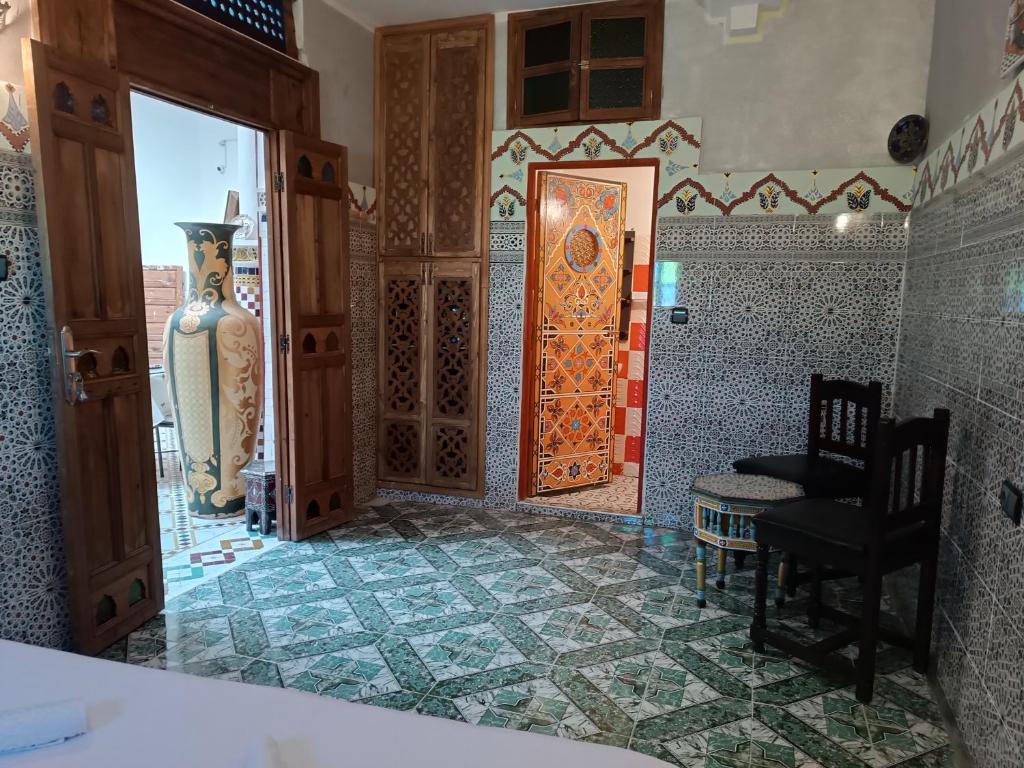 La salle de bains est pourvue d'une porte, d'une chaise et d'une table. dans l'établissement Riad Amira Fes, à Fès