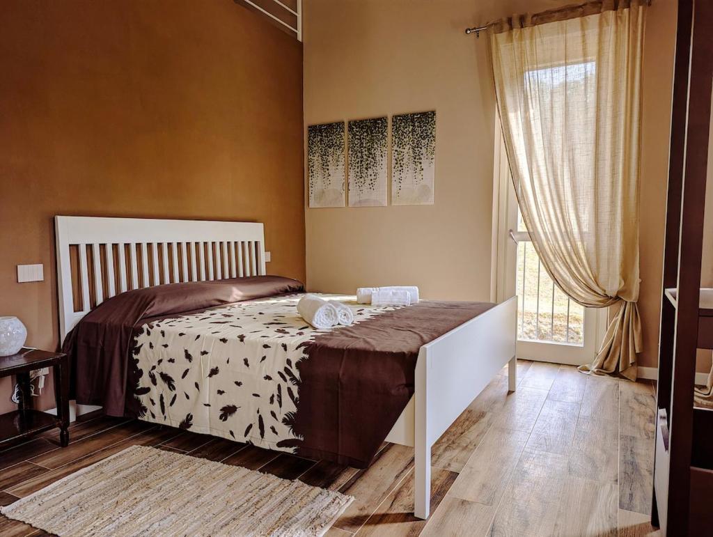 une chambre avec un lit et une grande fenêtre dans l'établissement Villa Grassi with private pool Nizza Monferrato, à Calamandrana