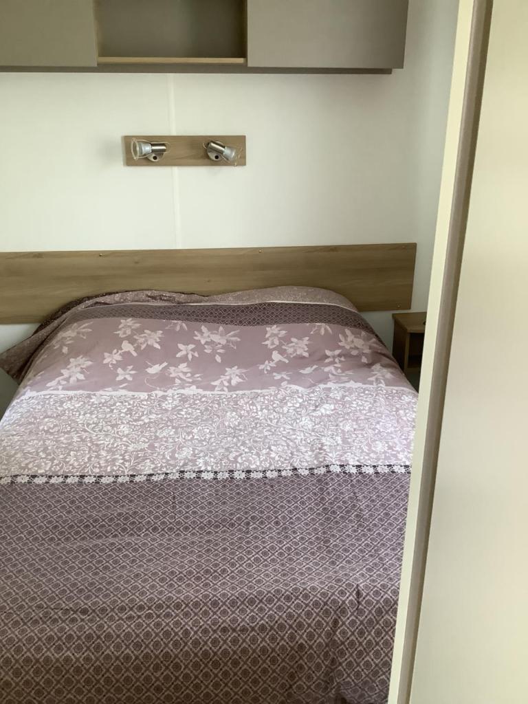 - un lit dans une petite chambre avec une couette violette dans l'établissement Montourey 83 ES 119, à Fréjus 12 autres photos