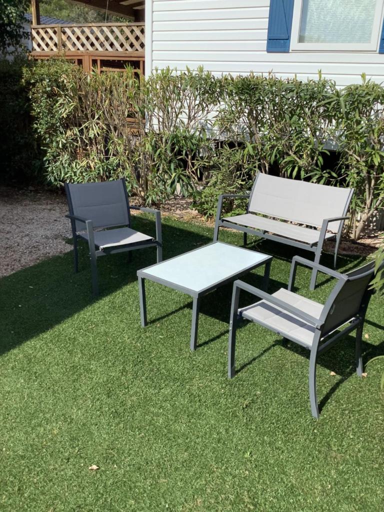 2 chaises, une table et un banc sur l'herbe dans l'établissement Montourey 83 ES 119, à Fréjus