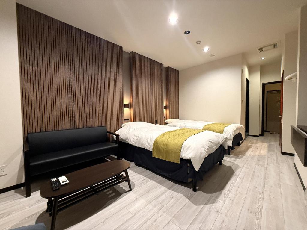 une chambre d'hôtel avec deux lits et un canapé dans l'établissement Hotel Hyper (Adult Only), à Osaka